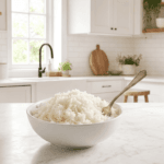 A white bowl of fluffy Instant Pot white rice with a fork on a marble counter