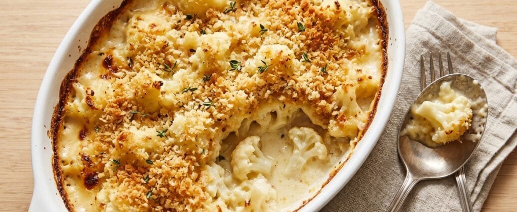 Cauliflower gratin in a white baking dish with a golden, crisp breadcrumb topping and fresh thyme