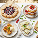 A bright overhead spread of summer desserts including strawberry shortcake, popsicles, sorbet, berry galette, and grilled peaches