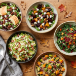 Overhead spread of fall salad recipes with roasted beets, apples, kale, and pomegranate