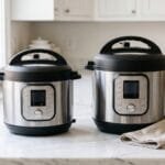 A smaller and a larger stainless steel electric pressure cooker side by side showing the size difference
